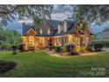 Beautiful brick home at dusk showcases manicured lawn, warm exterior lighting, and inviting curb appeal at 6024 Highview Rd, Weddington, NC 28104