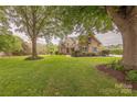 Charming brick home boasts a sprawling lawn, mature trees, and classic architectural details at 6024 Highview Rd, Weddington, NC 28104