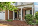 Inviting brick home with a covered porch, rocking chairs, and well-kept landscaping at 6310 Highland Commons Rd, Charlotte, NC 28269