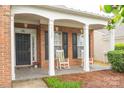Welcoming front porch with rocking chairs, black shutters, and an elegant entrance at 6310 Highland Commons Rd, Charlotte, NC 28269