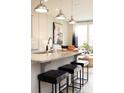 Kitchen island with stone countertops, modern pendant lighting, and seating for three at 7108 Hodges Meadow Ln, Charlotte, NC 28213