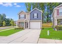 Charming two-story home featuring a manicured lawn and a welcoming two-car garage at 7205 Finnigan Rd, Charlotte, NC 28215