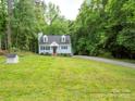Traditional home surrounded by lush greenery, featuring a classic design with dormer windows and a spacious front yard at 8905 Vagabond Rd, Mint Hill, NC 28227