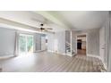 Bright and airy living room with new flooring, neutral walls, ceiling fan, and sliding glass doors leading outside at 8905 Vagabond Rd, Mint Hill, NC 28227