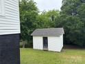 White outbuilding with a dark door surrounded by lush trees in the backyard at 103 Meadow Ne Ave # 6, Concord, NC 28025