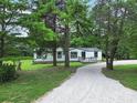 Single-story home on large lot, features include gravel driveway and cozy front porch at 10379 Turnplow Dr, Davidson, NC 28036