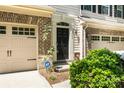 A townhouse front entry featuring a classic black door, brick accents, and tidy landscaping at 12009 Elizabeth Madison Ct, Charlotte, NC 28277