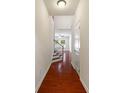 Hallway with hardwood floors, staircase, white trim, and natural light filtering in from nearby windows at 12009 Elizabeth Madison Ct, Charlotte, NC 28277