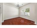Bright, empty living room with hardwood floors and a chandelier, ready for personalization at 12009 Elizabeth Madison Ct, Charlotte, NC 28277