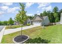 A well-maintained home exterior with a two-car garage and lush green lawn under a partly cloudy sky at 160 Tanner Loop, Troutman, NC 28166