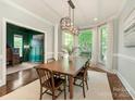 Elegant dining room featuring a large wooden table, stylish lighting, and ample natural light at 1814 Therrell Farms Rd, Waxhaw, NC 28173