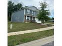 Charming two-story home with a landscaped front yard, blue siding, and stone accents under overcast skies at 184 Cherry Birch St, Mooresville, NC 28117