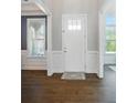 Bright foyer features a white front door, elegant trim, and rich hardwood flooring at 220 Forsythia Ln, Tega Cay, SC 29708