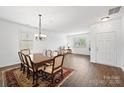 Elegant dining room with an ornate table, chandelier, and hardwood floors bathed in natural light at 2306 Nettleton Ct, Matthews, NC 28105