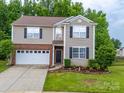 Traditional two-story home featuring a two-car garage, neutral siding, and neatly landscaped front yard at 2306 Nettleton Ct, Matthews, NC 28105