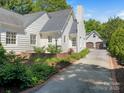 View of the side of the house, showcasing a long driveway leading to a two-car garage, framed by green landscaping at 2410 Vernon Dr, Charlotte, NC 28211