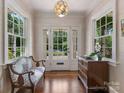 Bright foyer with hardwood floors, decorative lighting, a bench, and a view through the glass front door to the outside at 2410 Vernon Dr, Charlotte, NC 28211