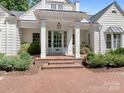 Close-up of the home's entrance with brick steps, white columns, and light blue door with glass panels at 2410 Vernon Dr, Charlotte, NC 28211