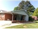 Home exterior featuring a covered side entrance, brick accents, and manicured landscaping at 2583 Robinson Rd, Newton, NC 28658