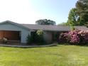 A view of the back and side of the home with manicured landscaping and beautiful flower bushes at 2583 Robinson Rd, Newton, NC 28658