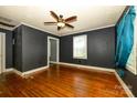 Living room features hardwood floors, dark walls, ceiling fan, and natural light at 2905 Grimes St, Charlotte, NC 28206