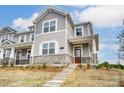 Beautiful two-story townhouse showcasing stone accents, gray siding, and a welcoming front porch entrance at 3936 Cheyney Park Dr, Charlotte, NC 28269