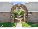 Charming courtyard view with brick archway, leading to a fountain and beautifully landscaped area at 5011 Sharon Rd # Q, Charlotte, NC 28210