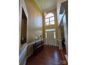 Grand foyer with tall ceilings, beautiful lighting fixture, and gorgeous hardwood floors at 6017 Lowergate Dr, Waxhaw, NC 28173