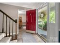 Bright foyer featuring a striking red front door and views into adjacent dining room at 6512 Porterfield Rd, Charlotte, NC 28226