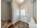 Inviting entryway features hardwood floors, a coat closet, and access to the staircase and main living area at 6917 Rothchild Dr, Charlotte, NC 28270