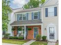Charming two-story townhome featuring a brick facade, covered porch, and beautifully landscaped front yard at 6917 Rothchild Dr, Charlotte, NC 28270