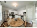 Bright kitchen with stainless steel appliances, granite counters, and dining area with a round wooden table at 6917 Rothchild Dr, Charlotte, NC 28270