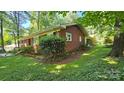 Well-maintained brick home with manicured landscaping and mature trees at 7021 Linda Lake Dr, Charlotte, NC 28215