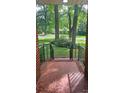 View from the covered front porch of a home with brick flooring and iron railings at 7021 Linda Lake Dr, Charlotte, NC 28215