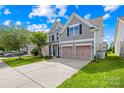 Inviting two-story home features a well-maintained lawn and a convenient two-car garage, all under a bright, sunny sky at 7316 Hamilton Bridge Rd, Charlotte, NC 28278
