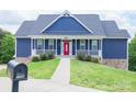Attractive blue home with a welcoming red front door, complemented by lovely landscaping and a sidewalk at 7768 Pinecone Ln, Hickory, NC 28602