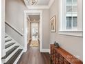 Charming entryway featuring hardwood floors, stairway, trim details, a window, and decorative furnishings at 7908 Rea View Ct, Charlotte, NC 28226