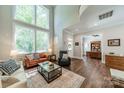 Bright living room boasting a soaring ceiling, large windows, and hardwood flooring at 815 Jetton St, Davidson, NC 28036