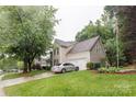 Inviting two-story home with a well-manicured lawn, mature trees, and attached two-car garage at 8532 Piccone Brook Ln, Charlotte, NC 28216
