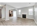 Spacious living room featuring a fireplace, hardwood floors, and an archway to the kitchen at 10606 Gallowgate Ln, Charlotte, NC 28213