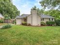 Charming home features a brick chimney, well-manicured lawn, and professional landscaping for eye-catching curb appeal at 1227 Seneca Pl, Charlotte, NC 28210