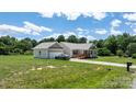 Exterior view of a charming single-story home featuring a detached garage and well-maintained lawn at 125 Carter Ln, Statesville, NC 28625
