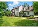 Traditional two-story home with beautiful lawn, manicured shrubs, and mature shade trees at 1295 Patterson St, China Grove, NC 28023
