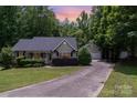 Lovely home with a detached garage and long driveway, surrounded by mature trees and a beautifully landscaped yard at 1318 Candlewood Dr, Gastonia, NC 28052