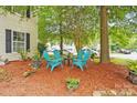 Cozy outdoor seating area with Adirondack chairs, perfect for relaxing in a landscaped front yard at 1332 Waterlily Ln, Charlotte, NC 28262