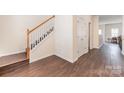Bright foyer features a staircase with wood railing and durable laminate flooring at 13612 Singleleaf Ln, Charlotte, NC 28278