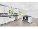 Renovated kitchen with stainless steel appliances, granite countertops, and sleek white cabinetry at 1408 Delview Rd, Cherryville, NC 28021