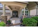 Inviting covered entry with decorative pillars, stone accents, and double doors that create a grand entrance at 14512 Brotherly Ln, Charlotte, NC 28278