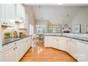 Spacious kitchen featuring white cabinets, granite countertops, hardwood floors, and an open layout at 14822 Rocky Top Dr, Huntersville, NC 28078