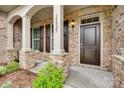 Inviting front porch with stone accents, sturdy pillars, and a stylish dark front door at 15927 Vale Ridge Dr, Charlotte, NC 28278
